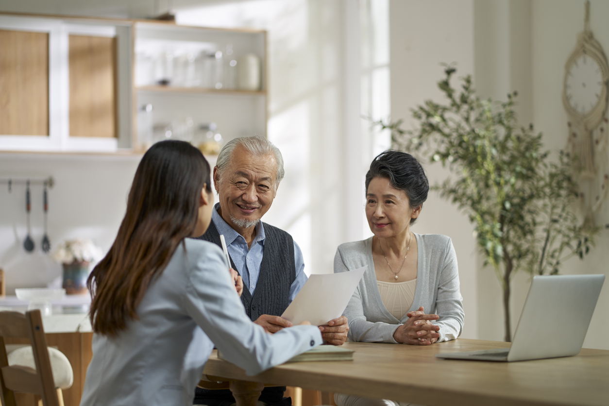asian sales woman selling product to old couple